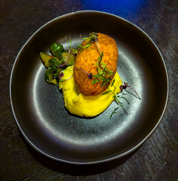 istock Crispy Cutlet with Creamy Mashed Potatoes and Pickles in a Black Bowl 2203984188