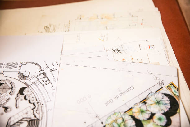 Stack of various documents and papers related to building plans and architectural designs for a construction project. Includes detailed sketches, blueprints, and design elements for accurate planning.