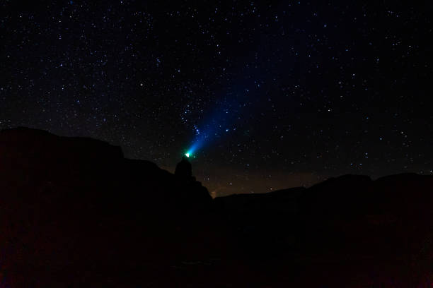 Hiker with headlamp illuminates night sky, below Matterhorn Peak, Valais, Swiss Alps