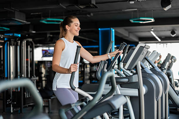 istock Active athlete young woman engaged in intensive high interval training on ellipsoid simulator in gym 2203989316