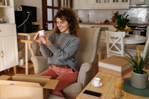 istock Satisfied woman opening a postal delivery 2203991932
