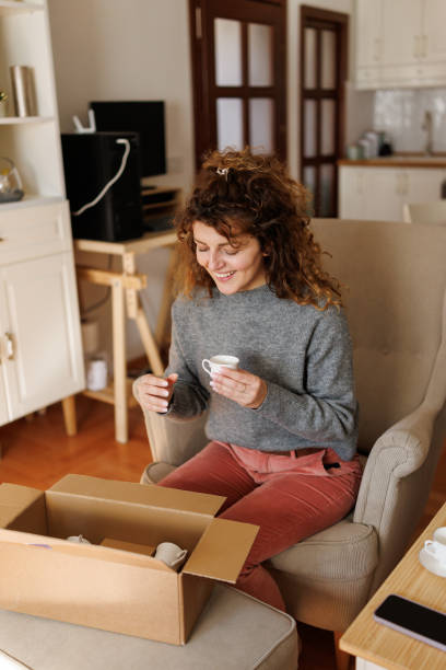 istock Satisfied woman opening a postal delivery 2203991940