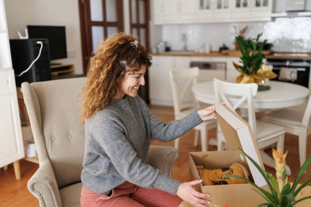 istock Happy woman unpacking box after online shopping 2203992015