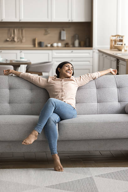 istock Millennial female relax on comfortable sofa at cozy domestic interior 2203993541