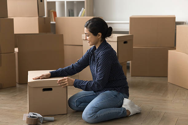 istock Smiling young saleswoman ecommerce shop manager pack boxes on floor 2203993864
