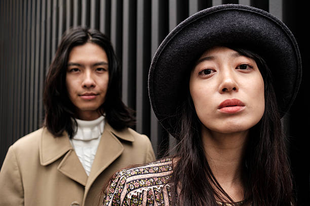 istock Serious asian couple posing in front of a modern building 2203994233