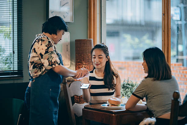 istock Asian Female Customer Scanning Smartphone Payment Code for Checkout: Cashless Payment and Technological Convenience in Modern Shopping Experience 2203995643