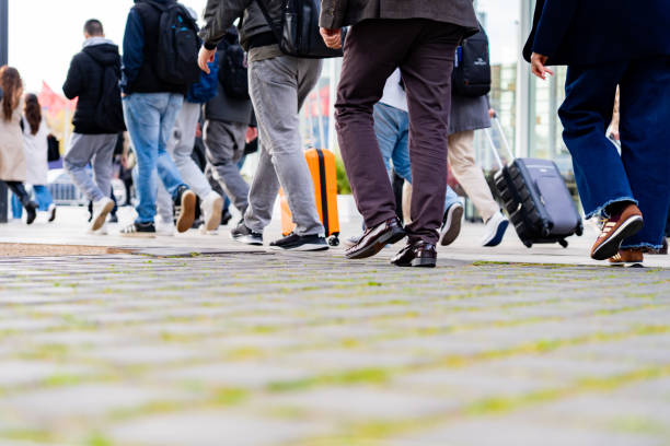 Barcelona, Spain. 03/06/2025. Mobile World Congress (MWC) held at the Fira of Barcelona. Tourists walking on cobblestone street with rolling suitcases