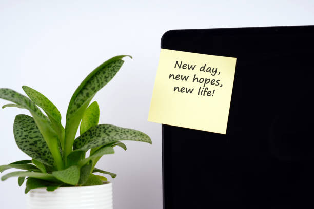 istock Adhesive note on a laptop screen with text - New day, new hopes, new life 2204001476