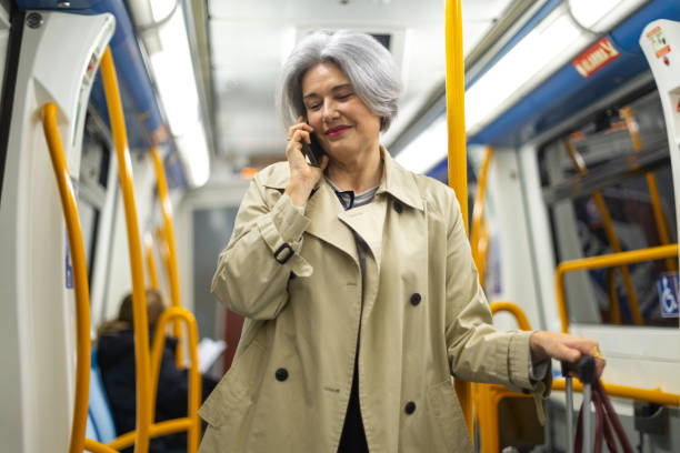 istock Elegant senior woman talking on smartphone while riding subway train 2204002078