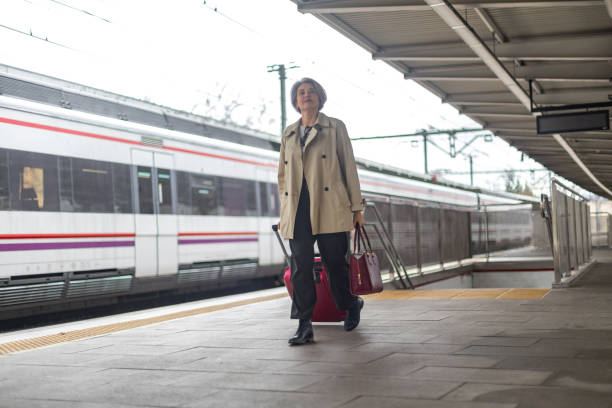 istock Businesswoman walking with suitcase at train station 2204002096