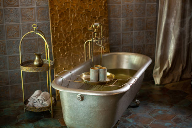 istock Golden bathtub with water and candlesticks 2204002293