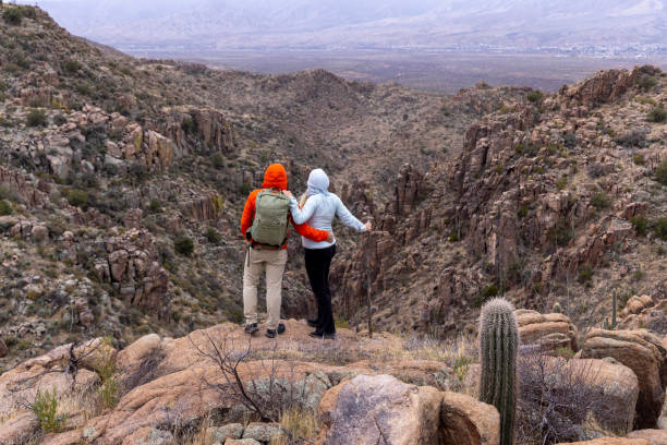 istock Hikers pause on edge of canyon in desert 2204003581