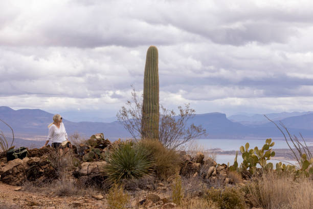 Mature woman hiker pauses on hilltop above Roosevelt Lake, Tonto Basin, AZ