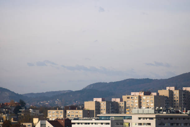 A cityscape featuring residential high-rise buildings with distant hills in the background. The mix of modern and older apartment blocks creates a diverse urban view.