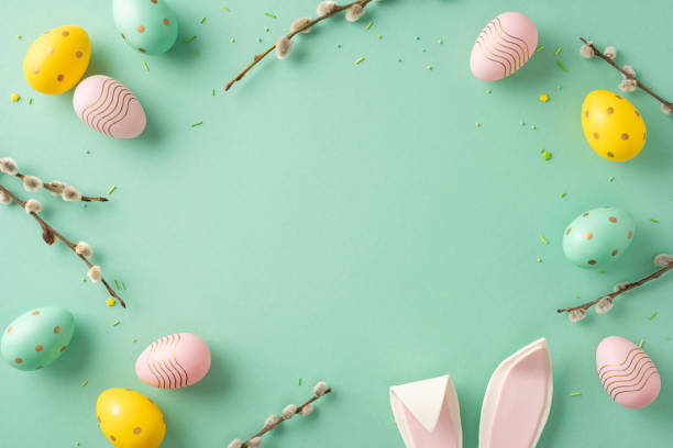 istock A festive Easter-themed composition with colorful decorated eggs and bunny ears against a pale green background 2204010881