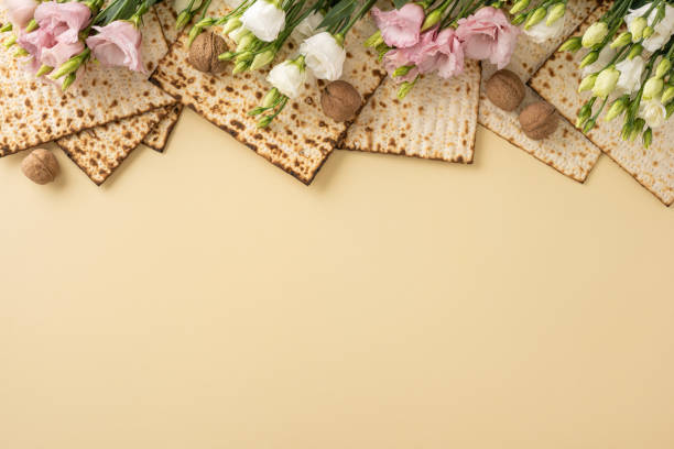 istock Matzo arranged with delicate pink and white flowers alongside walnuts on a beige surface 2204010889