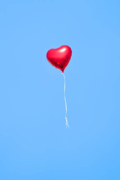 Heart shaped balloon rising into the sky