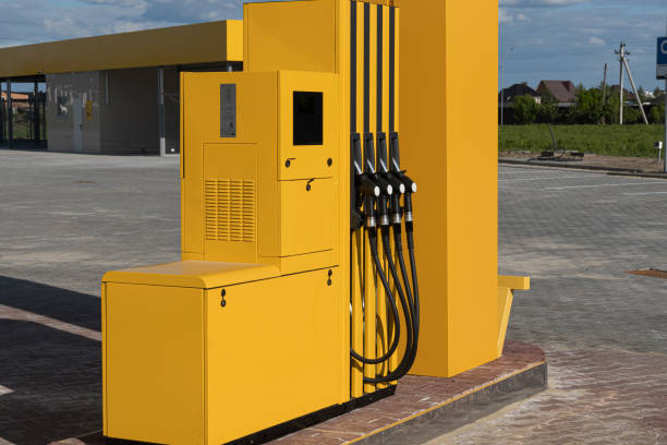 istock Fuel dispenser with multiple nozzles stands alone at a gas station, surrounded by open space and well-maintained surfaces under a clear sky 2204016041