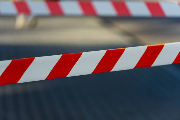 istock Brightly colored barricade tape indicates a restricted area at a construction site in an urban environment under clear sky 2204016096