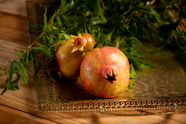 Pomegranates, beautiful freshly picked pomegranates on a wonderful tray on a rustic surface, selective focus