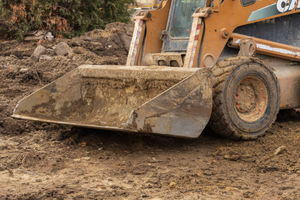 istock Heavy machinery works on earthmoving tasks at a construction site covered in mud and debris under overcast skies 2204016182
