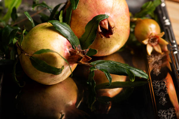 istock Pomegranates, beautiful freshly picked pomegranates on a wonderful tray on a rustic surface, selective focus 2204016249