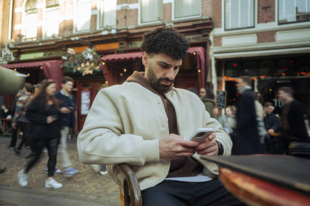 istock Young man using smartphone in busy city center 2204022320