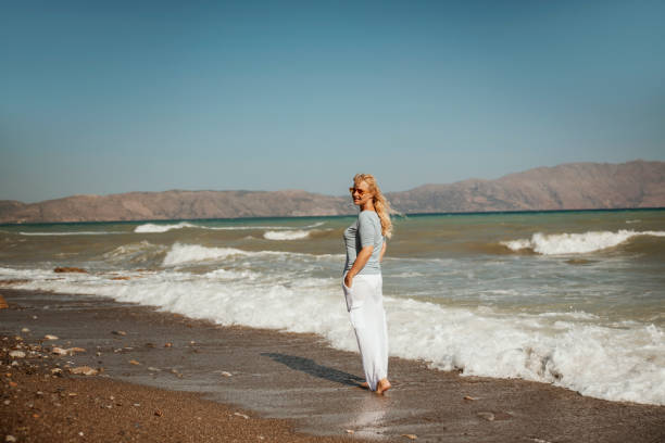 Mid adult carefree woman walking on the beach
