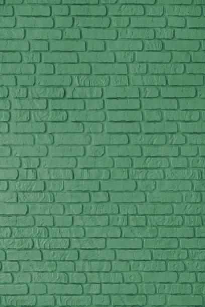 istock Green color painted brick wall texture, brickwork, masonry of stone blocks vertical background 2204030506