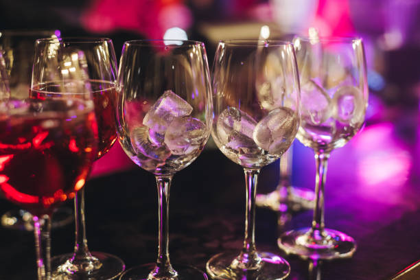 istock Bartender working, barman mixing and pouring drinks and beverages in a club, beautiful row line of different red coloured liquor alcohol cocktails on a party in a bar, catering banquet on event 2204032648