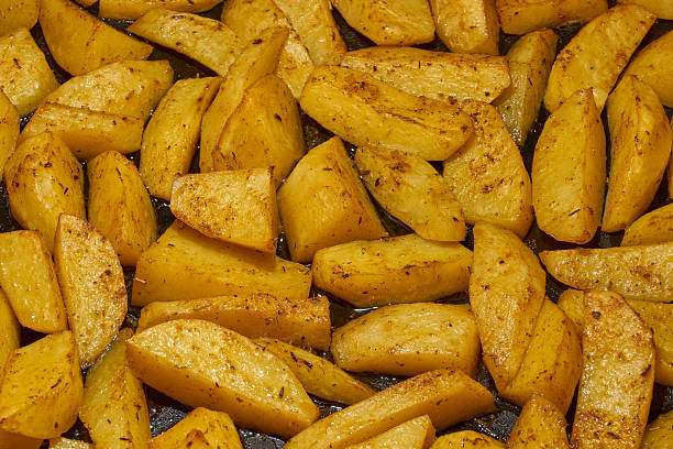 istock Baked potato slices with seasoning mixture. 2204034005