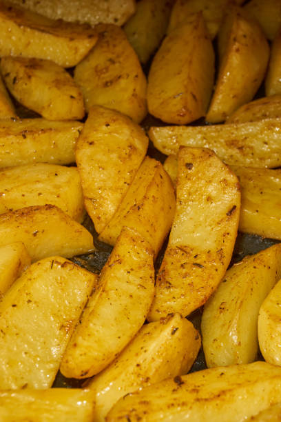 istock Baked potato slices with seasoning mixture. 2204034007