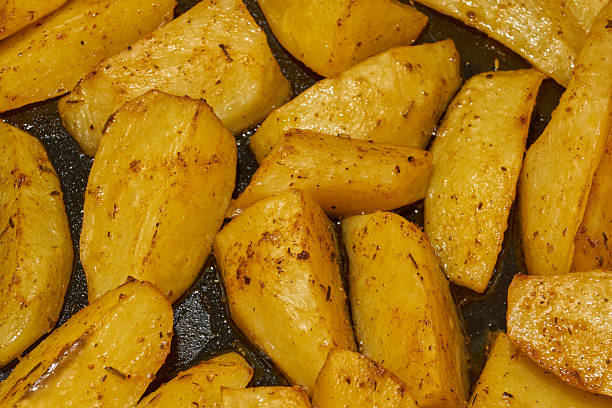 istock Baked potato slices with seasoning mixture. 2204034038