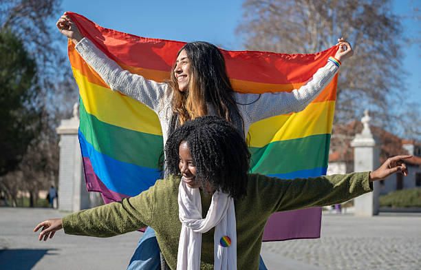 istock Two smiling diverse women holding rainbow flag celebrating lgbt pride 2204035104