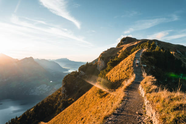 istock Young man hikes on mountain ridge above lake 2204035664