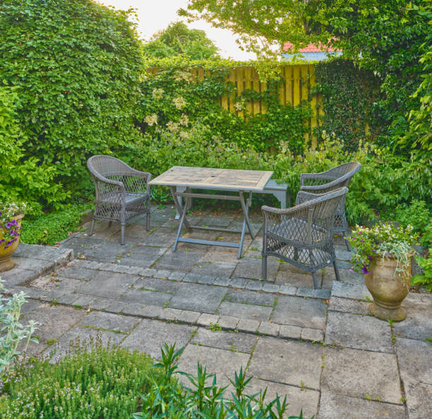 Cozy garden seating area surrounded by lush greenery and blooming plants