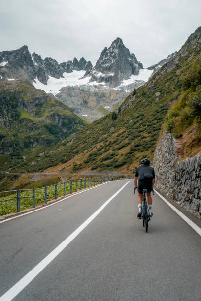 istock Road biker rides up high mountain pass 2204038363
