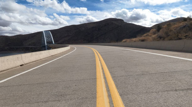 View down highway towards Roosevelt Lake Bridge in desert landscape, Tonto Basin, Arizona