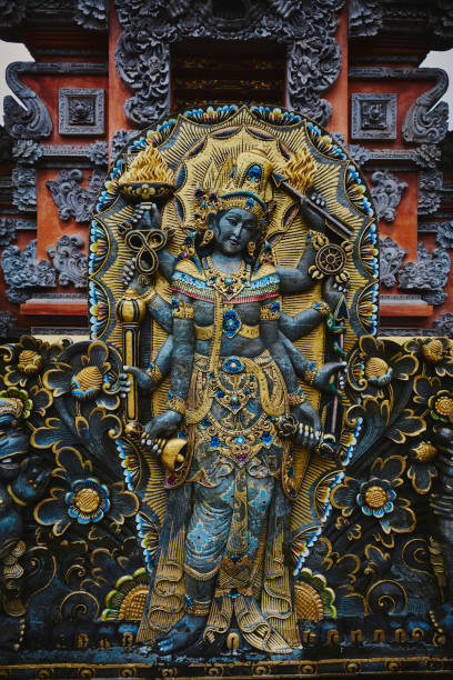 Stone sculpture artwork at the temple of Pura Beji Sangsit Temple in Singajara, Bali, Indonesia. The European faces depicted note the Dutch influence on Indonesian culture.