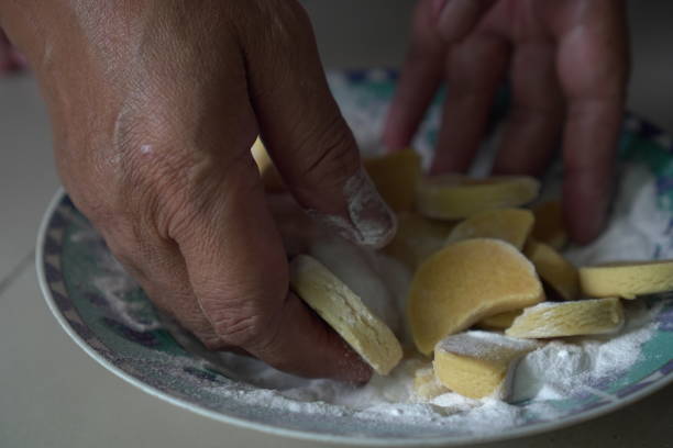 istock Coating freshly baked Putri Salju cookies with powdered sugar 2204050556