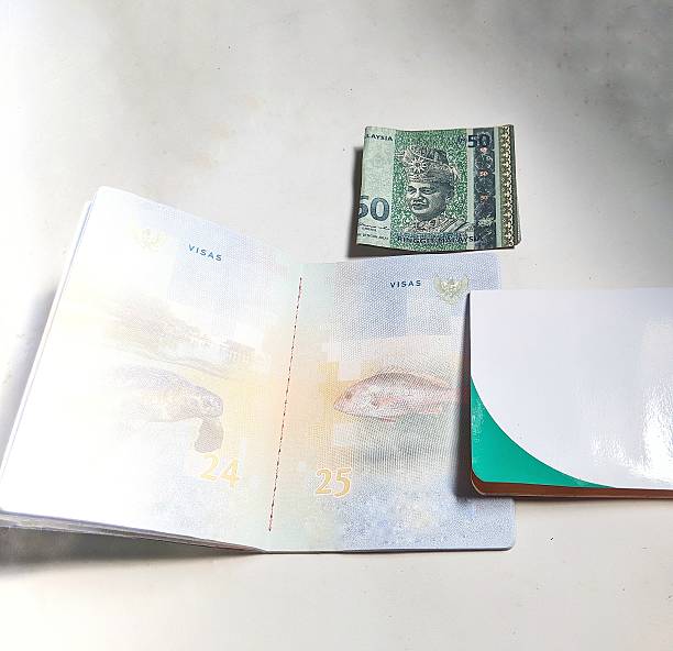 istock hands holding Indonesian passport overlapping with savings book 2204052762