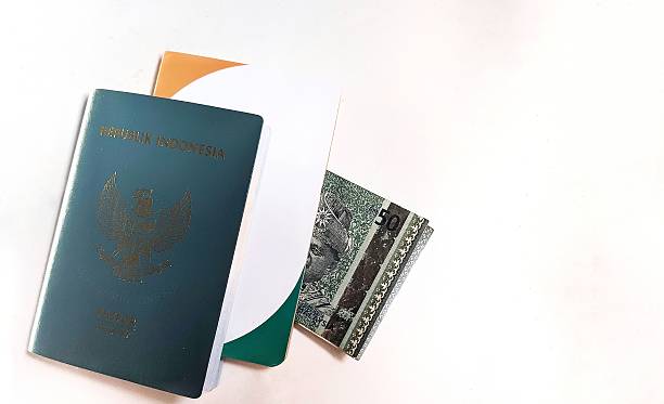 istock hands holding Indonesian passport overlapping with savings book 2204052778