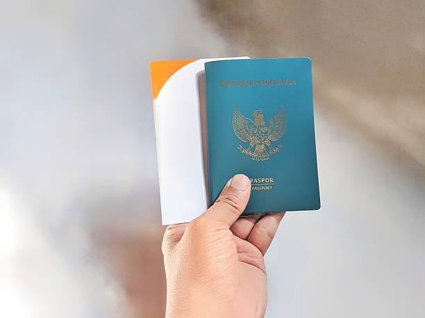istock hands holding Indonesian passport overlapping with savings book 2204052788