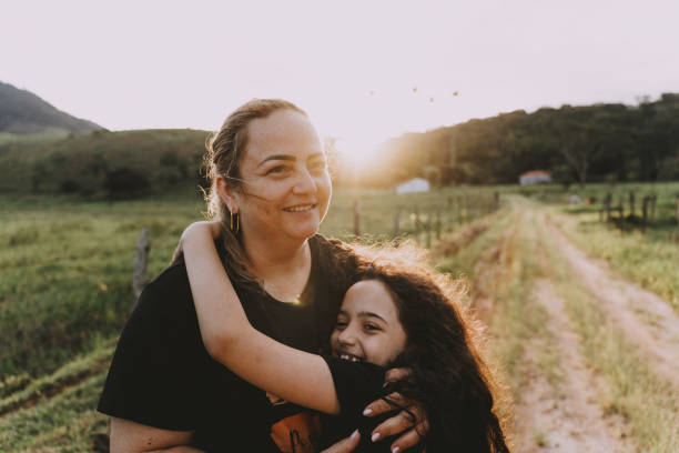 Mother hugging daughter on farm