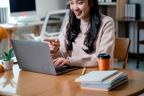 istock Remote female professional gesturing during virtual meeting with laptop, smiling confidently 2204056516