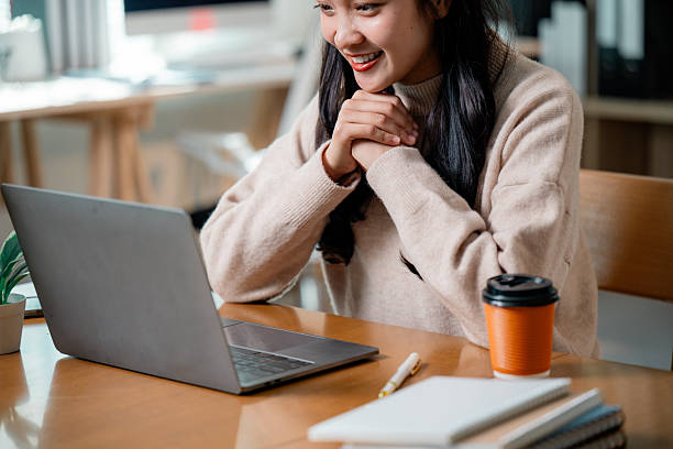 istock Female professional typing on laptop, working remotely with cheerful expression 2204056539