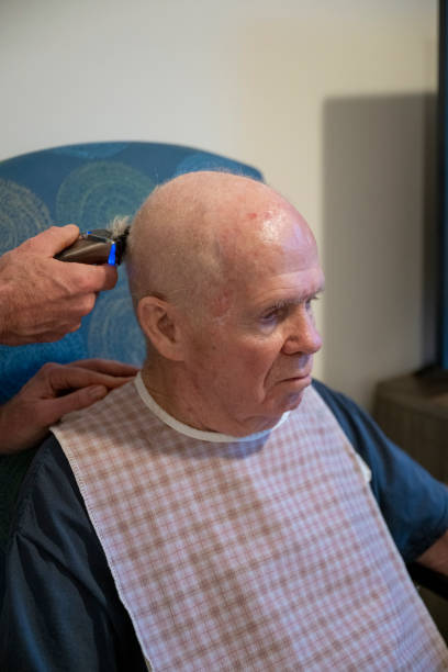 istock Adult son cuts senior man's hair 2204058049