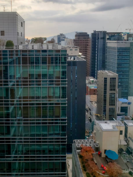 Incheon, S. Korea - Dec 3, 2019: Elevated morning view of city skyline. High-rise modern buildings as photographed through a window. Dramatic skyscape.