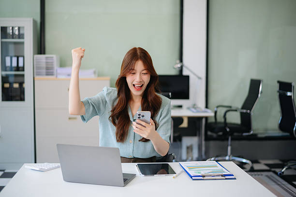 istock Asian woman using laptop and tablet while sitting at her working place. Concentrated 2204060241